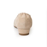 Beige suede cap-toe flat with black toe, s showing 0.75-inch wedgeback view