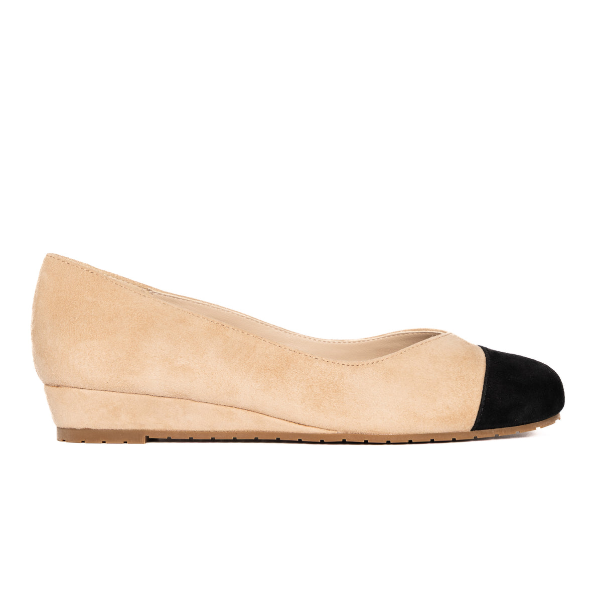 Beige suede cap-toe flat with black toe, side profile showing 0.75-inch wedge