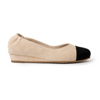 Beige suede cap-toe flat with black toe, side profile showing 0.75-inch wedge